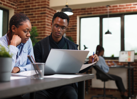 An African American man and woman examining a report. Representing a minority-owned small business.