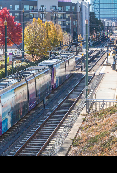 The light rail moving  through a newly redeveloped community.